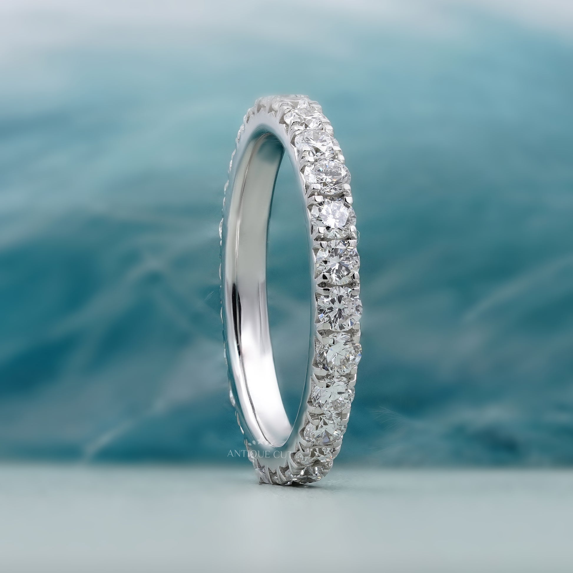 Silver ring with diamonds on a soft blue background

