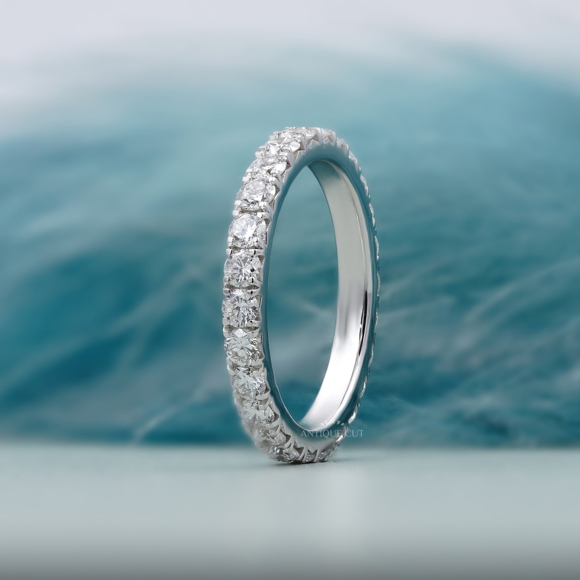 Silver ring with diamonds on a soft blue background

