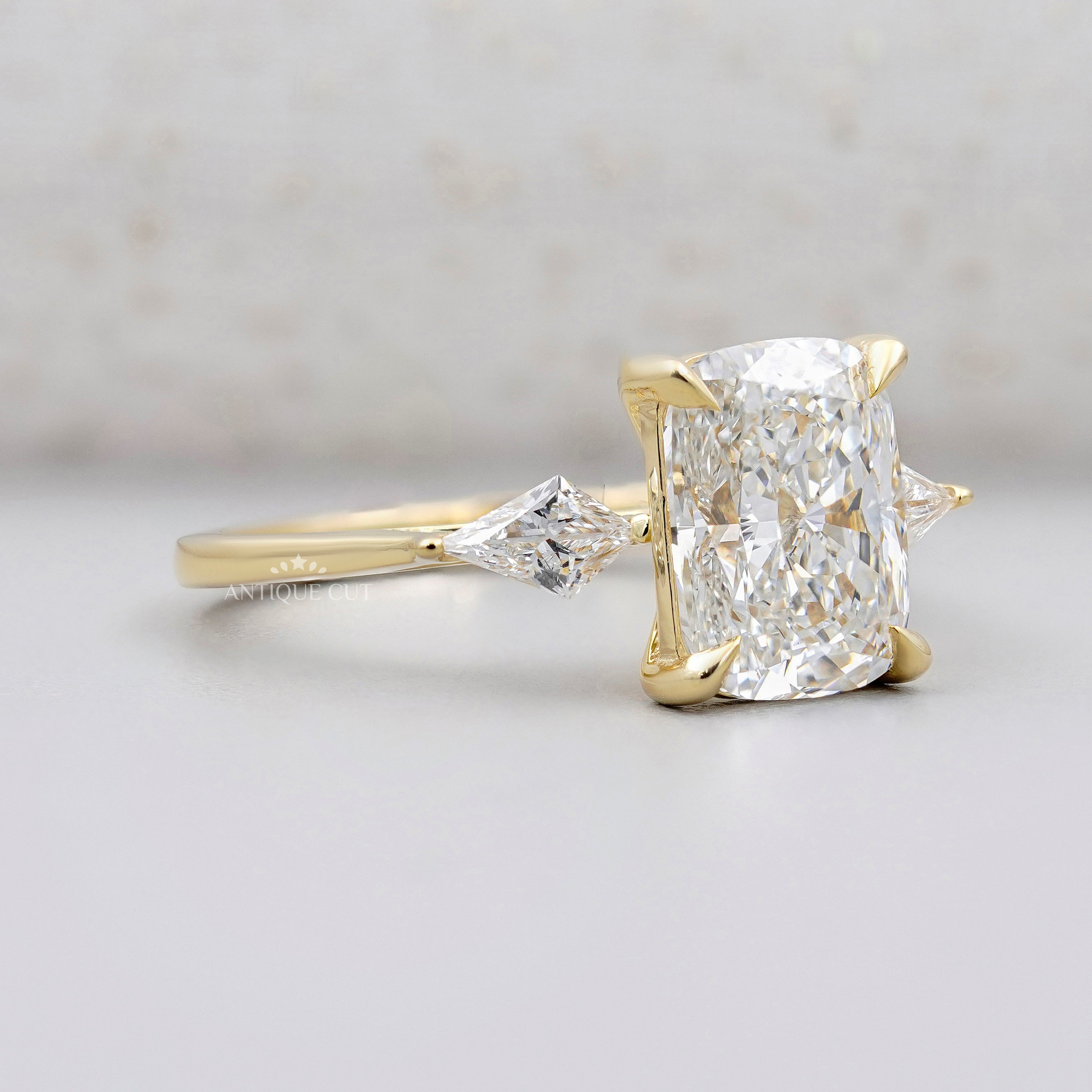 Elongated cushion cut diamond engagement ring with kite side stones in yellow gold