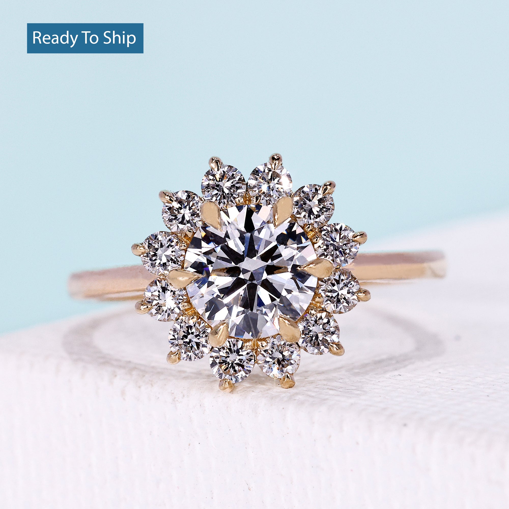 Floral halo round engagement ring with yellow gold setting
