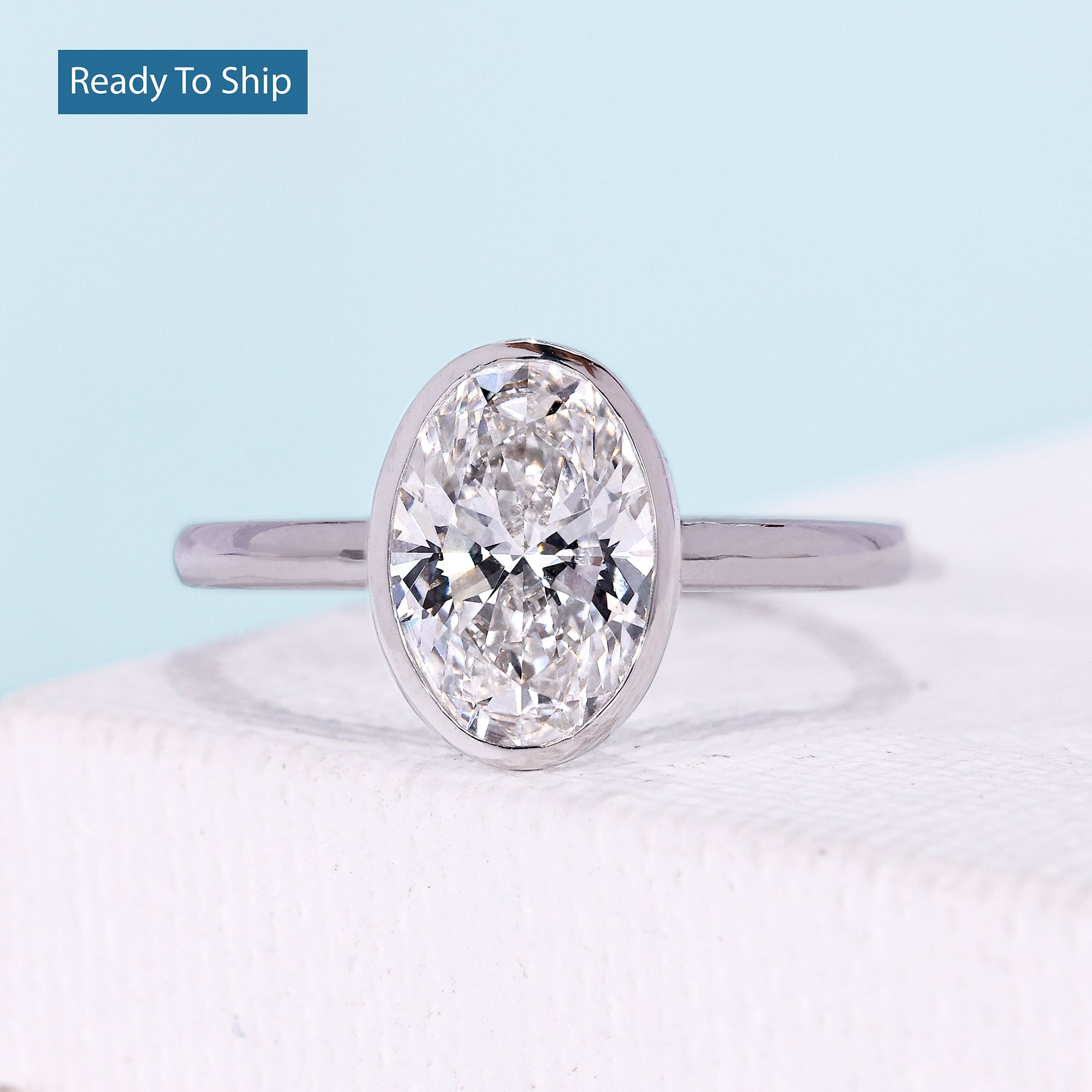 Oval cut engagement ring with bezel setting in white gold
