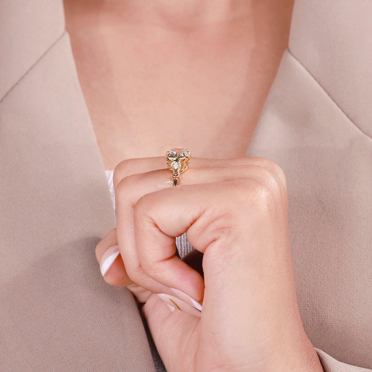 Three-quarter view of old mine cushion diamond ring with side stones