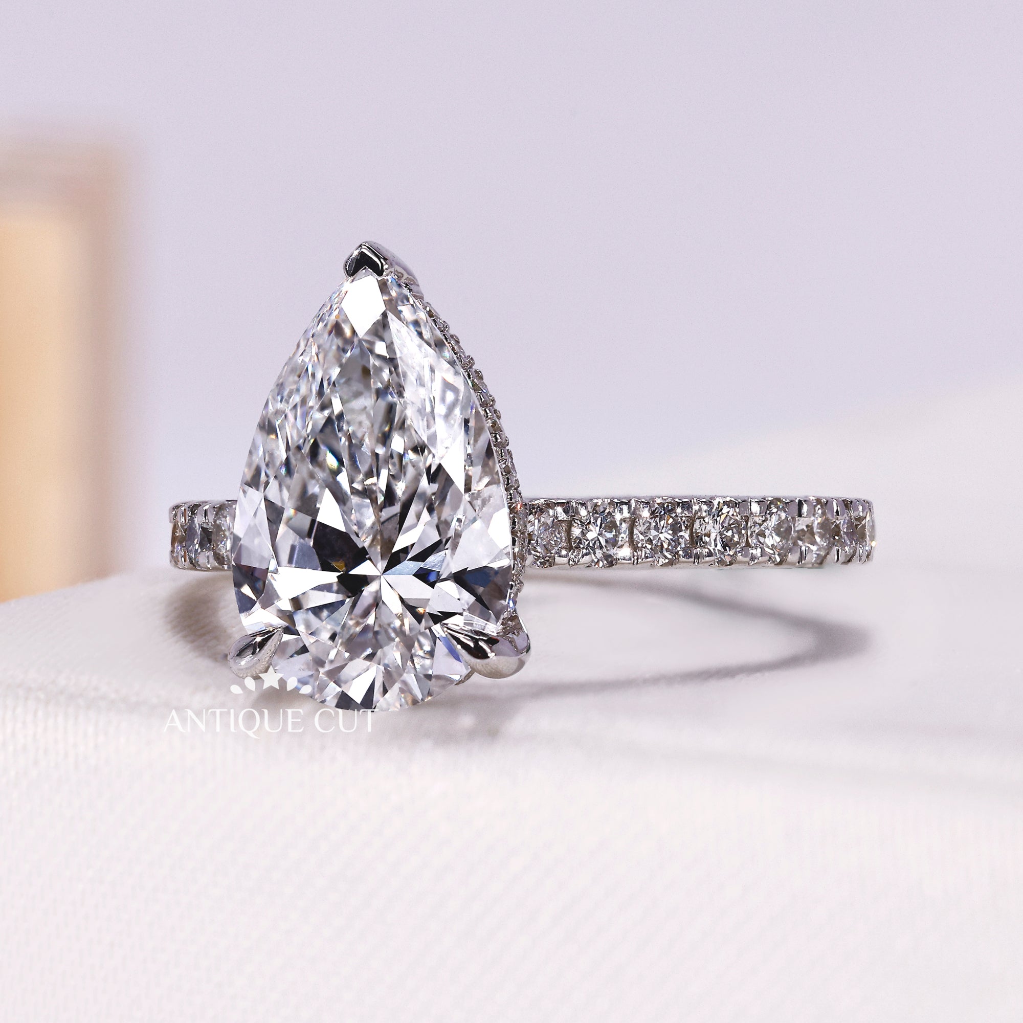 Pear cut lab diamond engagement ring with diamond pavé shank