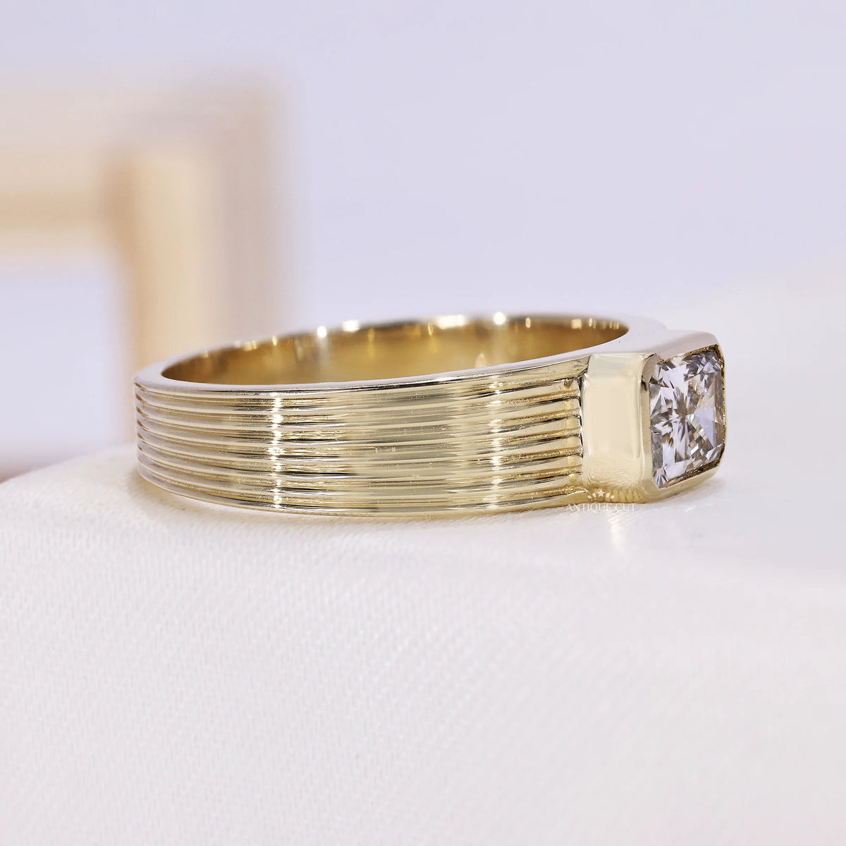 Yellow gold lab grown diamond ring featuring an emerald cut center stone
