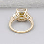 Gold ring with a large yellow diamond and smaller clear diamonds on a light gray background

