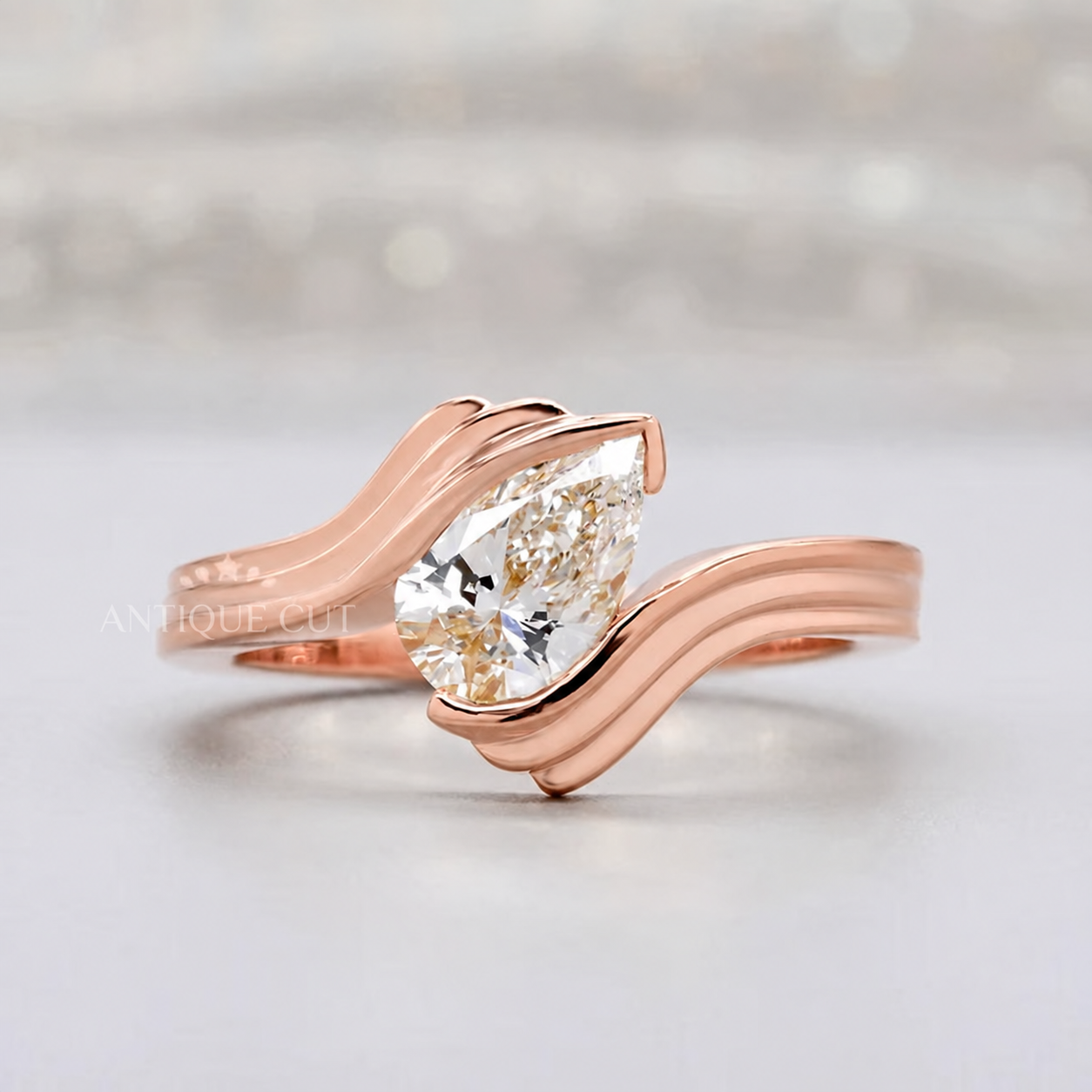 winding swirl band with a teardrop-shaped pear-cut center stone