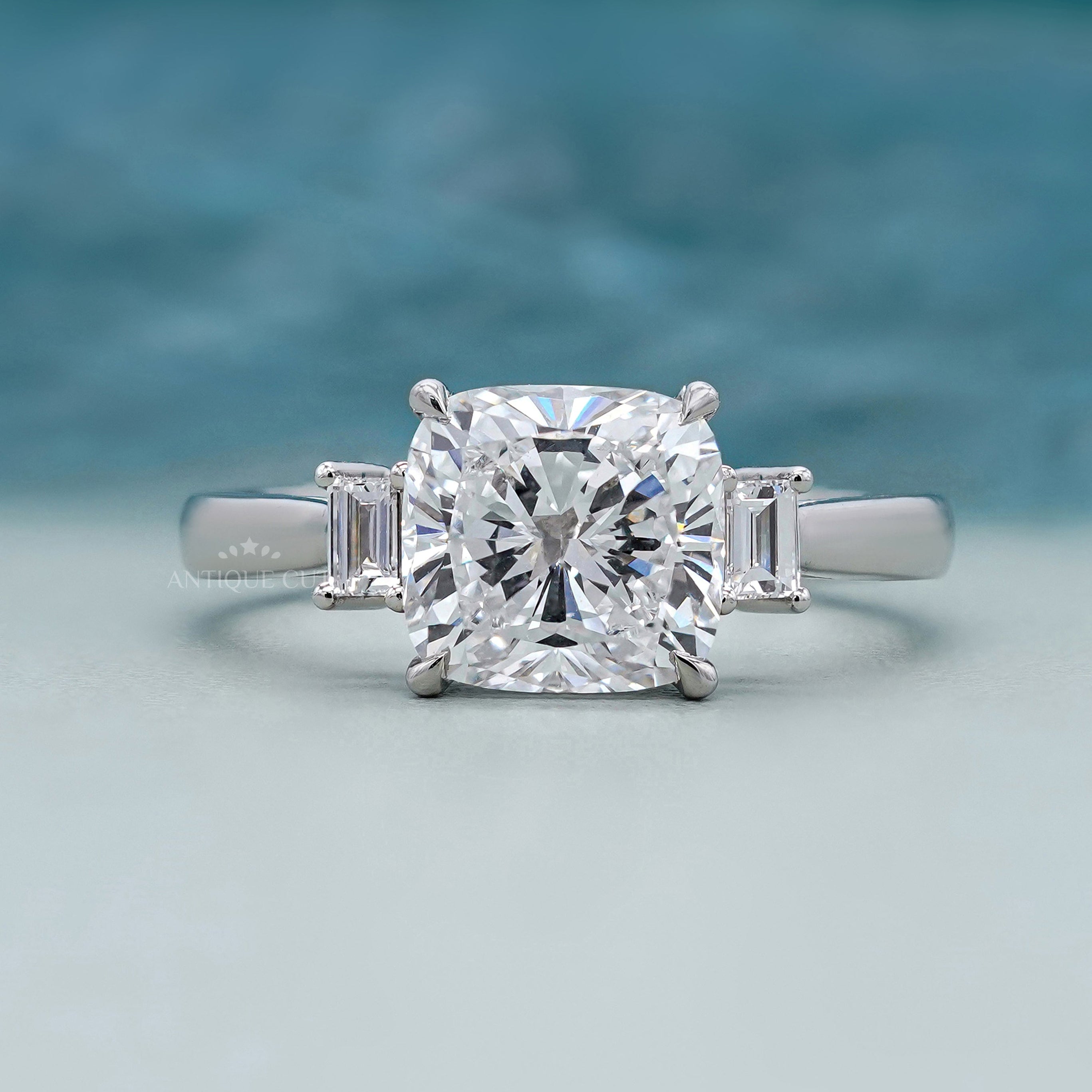 Three stone cushion cut engagement ring in white gold