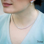 Woman wearing diamond necklace and earrings.