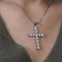 Gold cross necklace with diamonds on a person's neck

