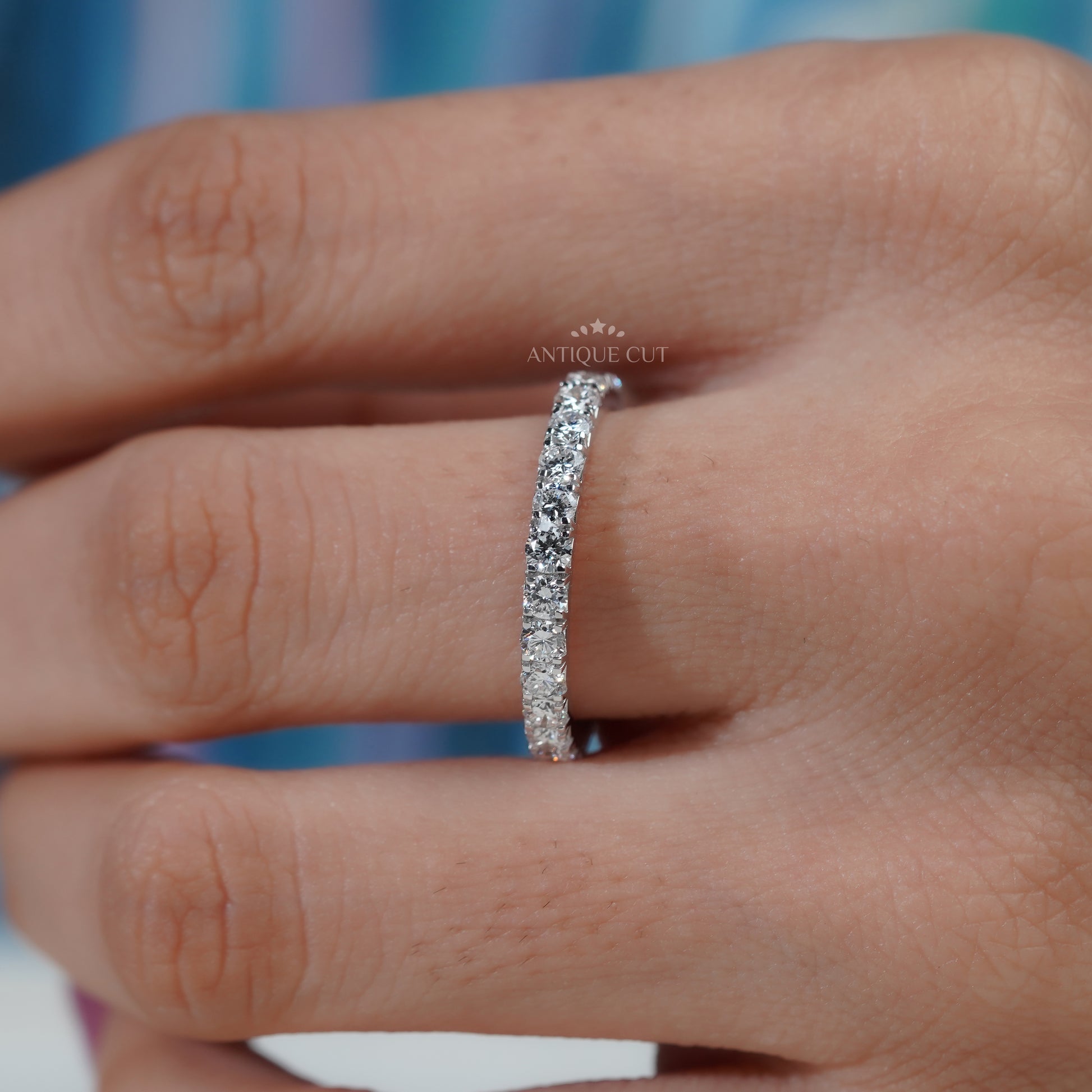 Silver ring with diamonds on a soft blue background


