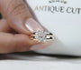 Wide band yellow gold engagement ring with radiant cut center diamond