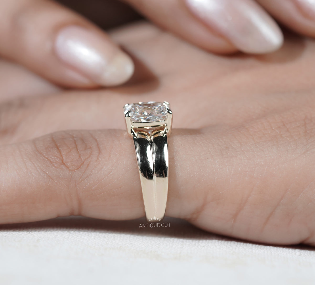 Elongated radiant diamond engagement ring mounted on a bold yellow gold band