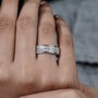 Close-up of a hand wearing a silver ring with gemstones