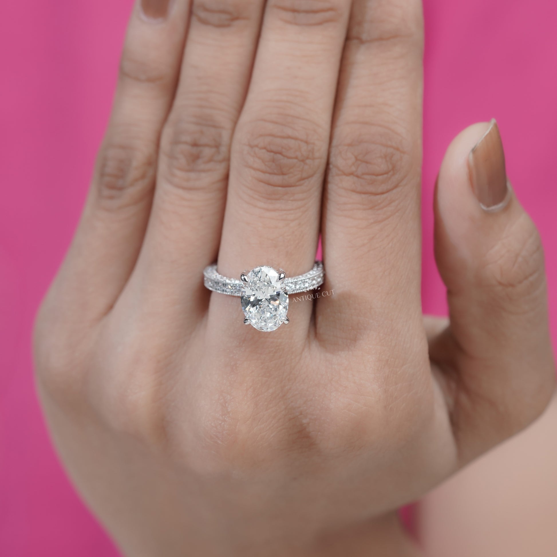 Oval cut engagement ring with pavé diamond band and hidden halo