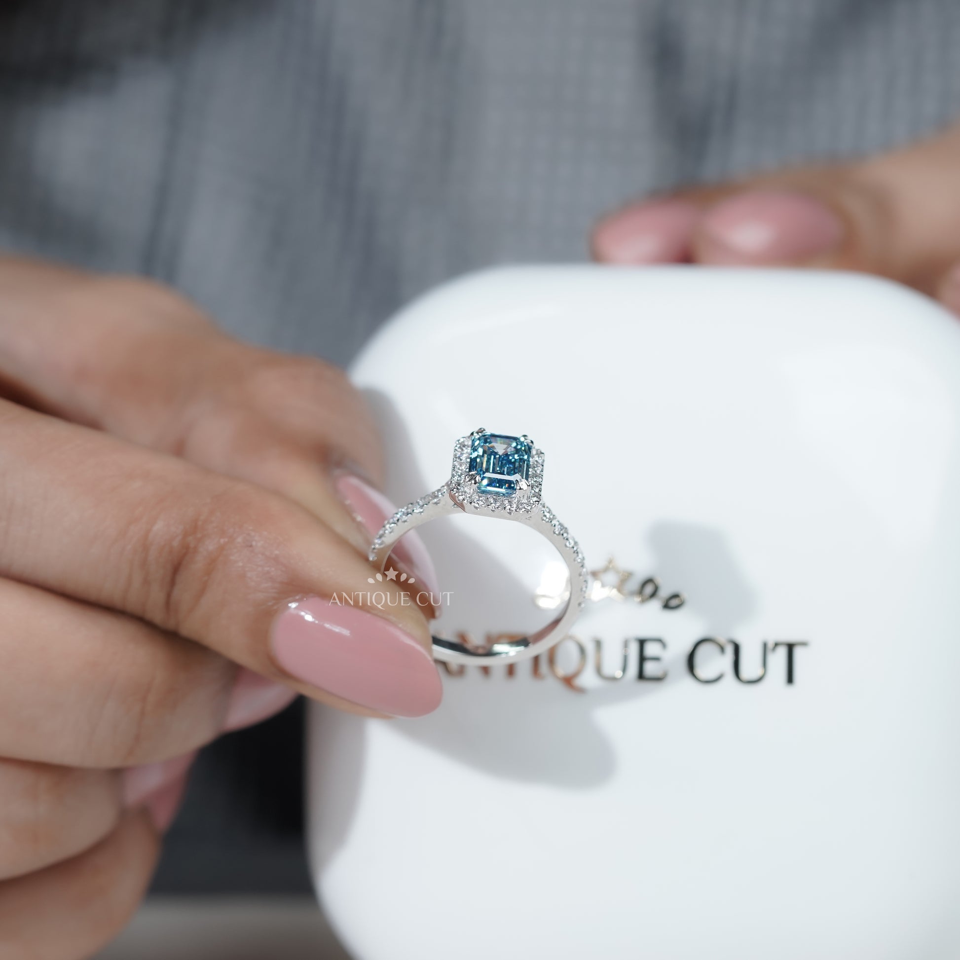 Close-up of a hand wearing a ring with a blue gemstone on a natural background

