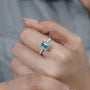 Emerald halo fancy blue diamond ring with pave band
