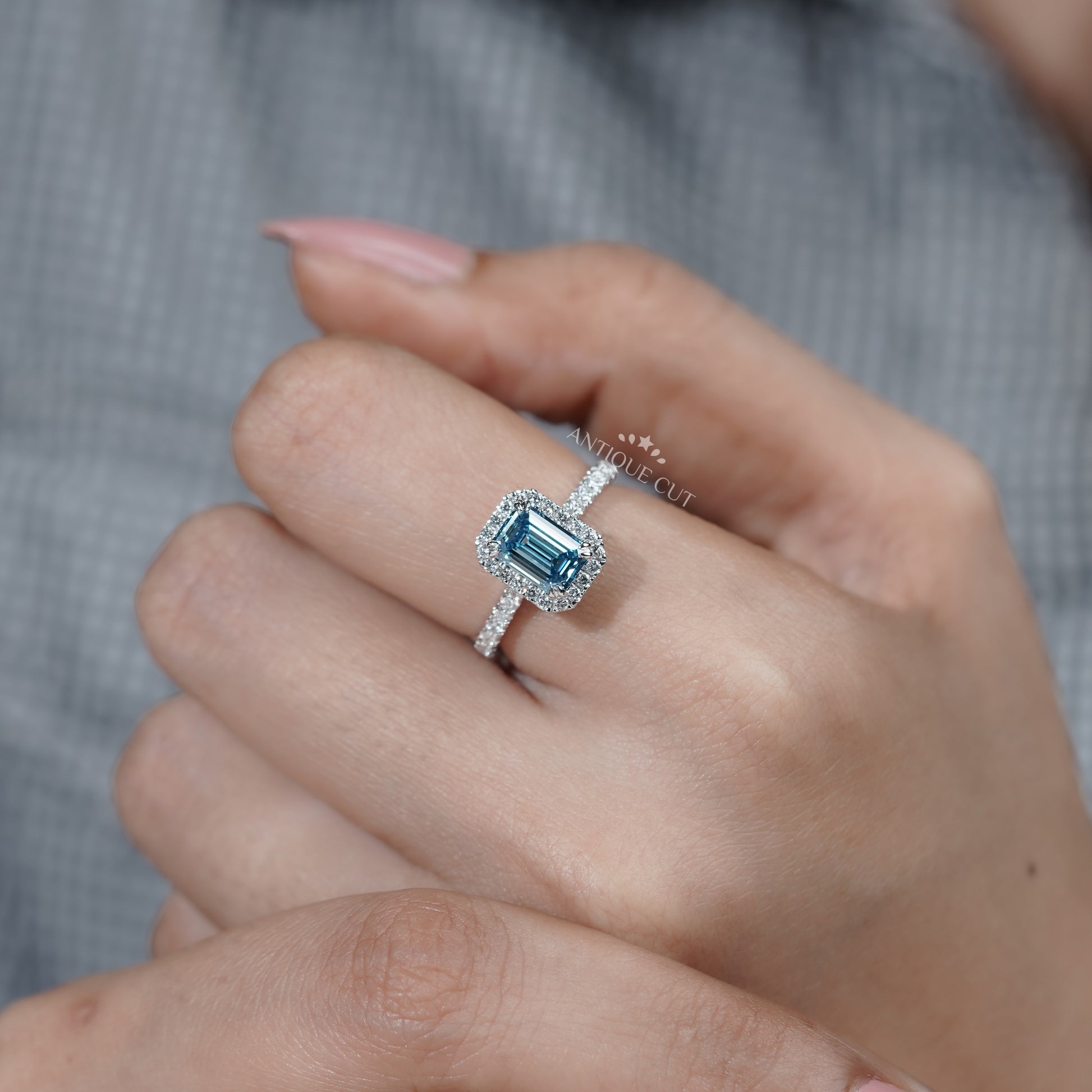 Emerald halo fancy blue diamond ring with pave band
