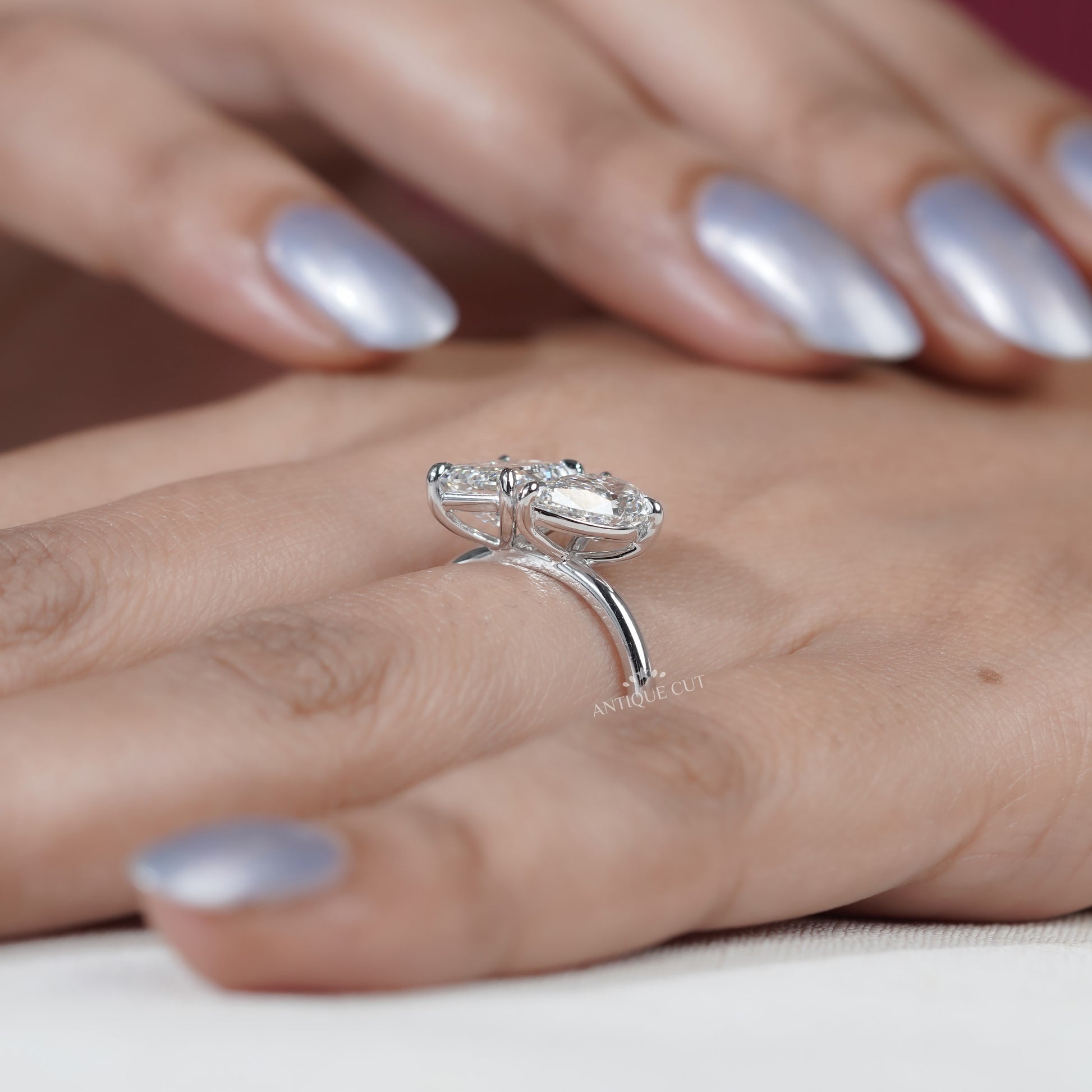 Emerald cut diamond with pear side stone engagement ring