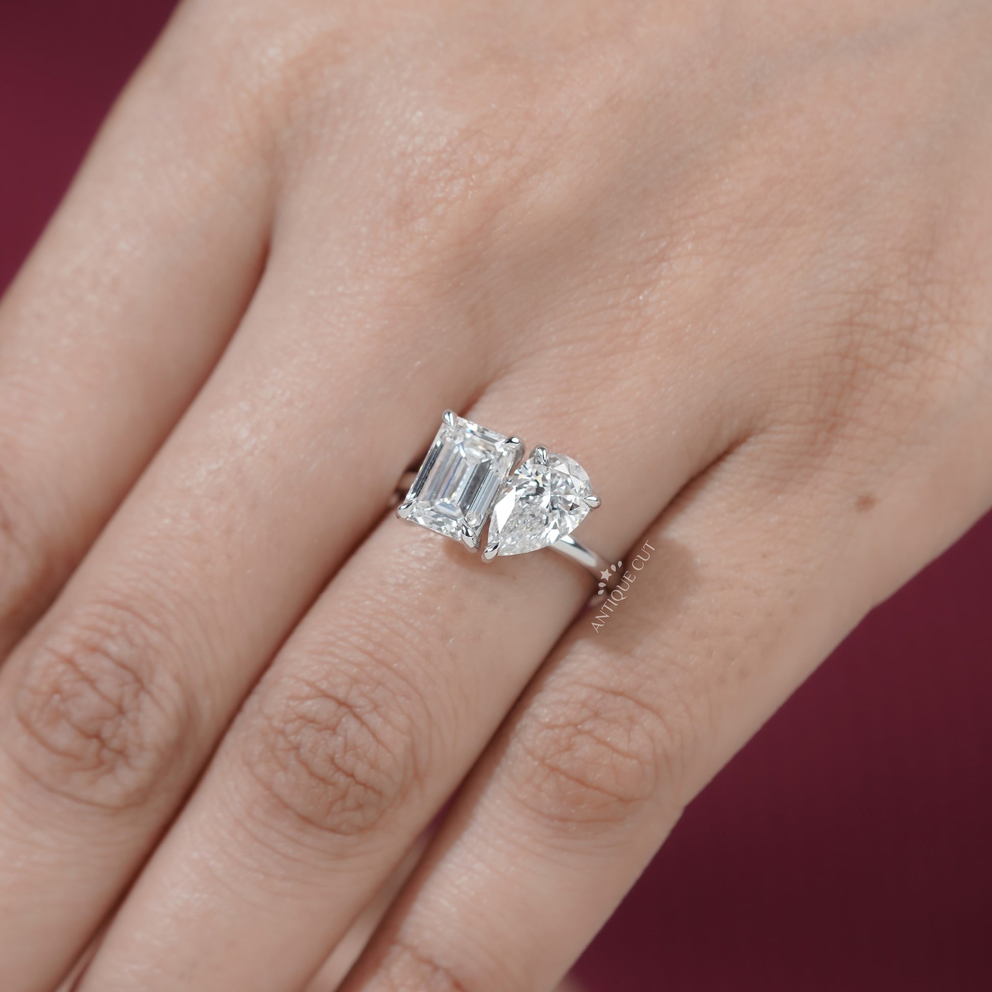 White gold two stone engagement ring with emerald and pear diamonds