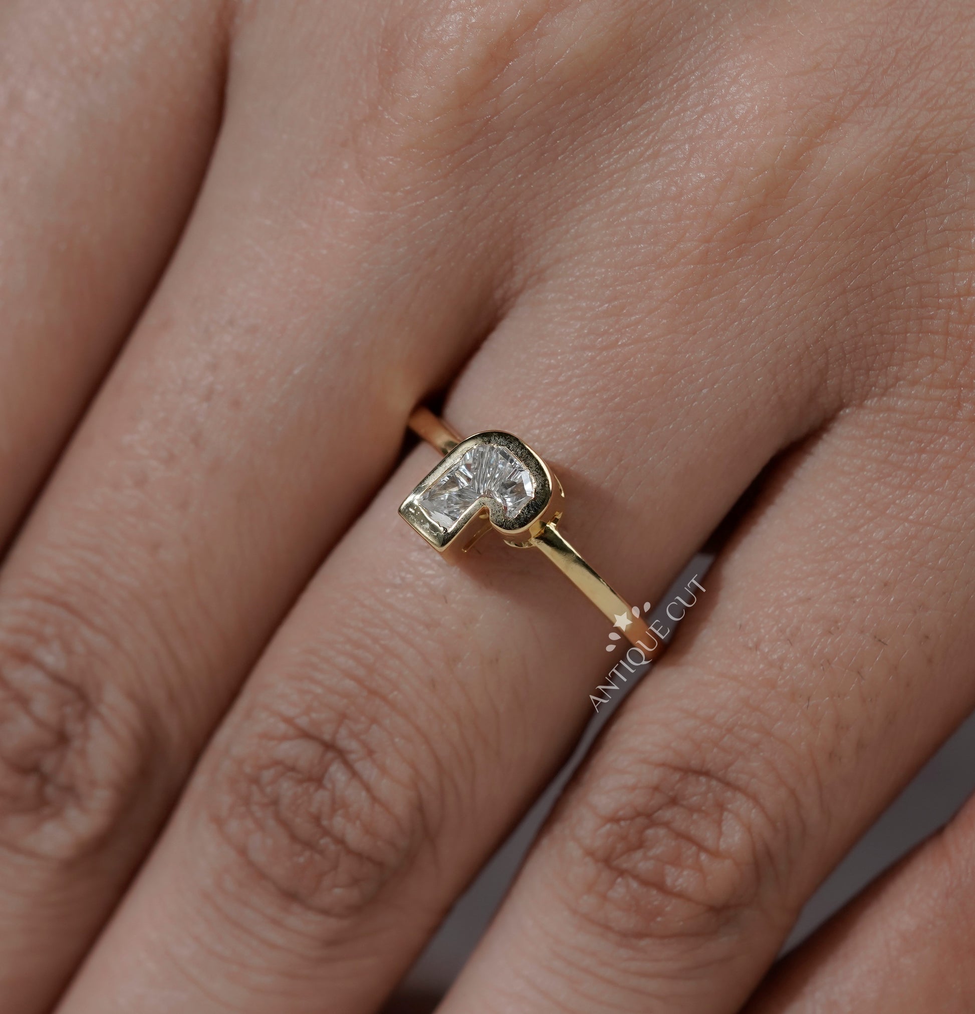 J shaped diamond ring with bezel set lab grown diamond and yellow gold band