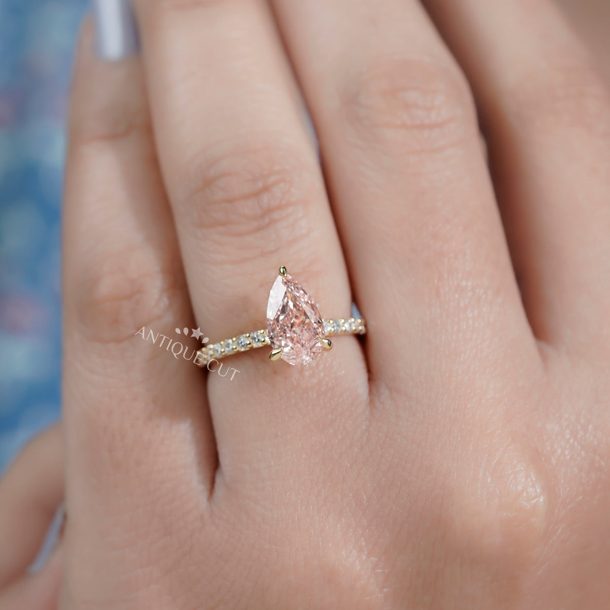 Fancy pink diamond ring featuring pear cut center stone
