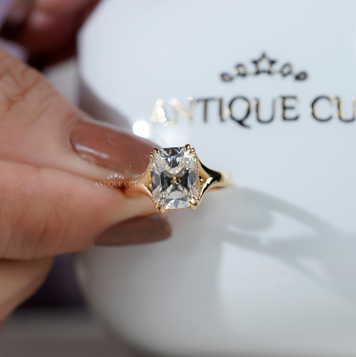 Radiant diamond solitaire ring with raised yellow gold setting