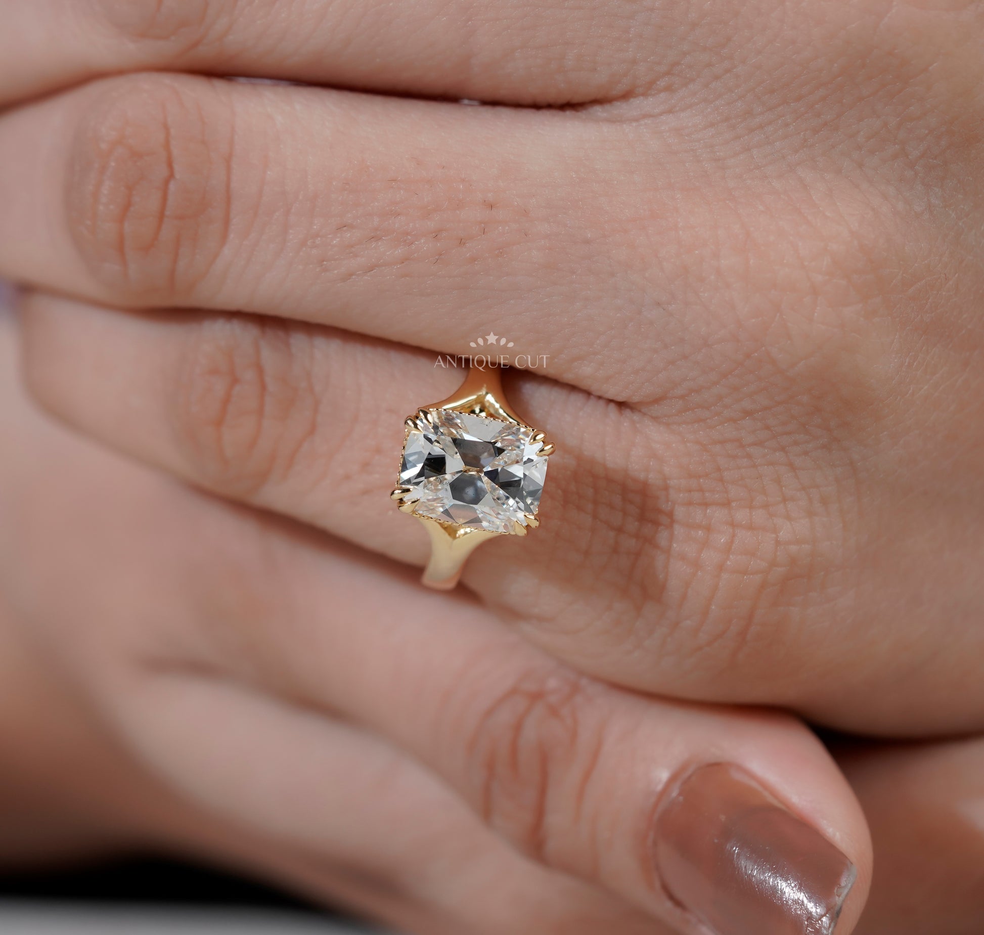 Yellow gold radiant diamond ring with sculpted cathedral shoulders