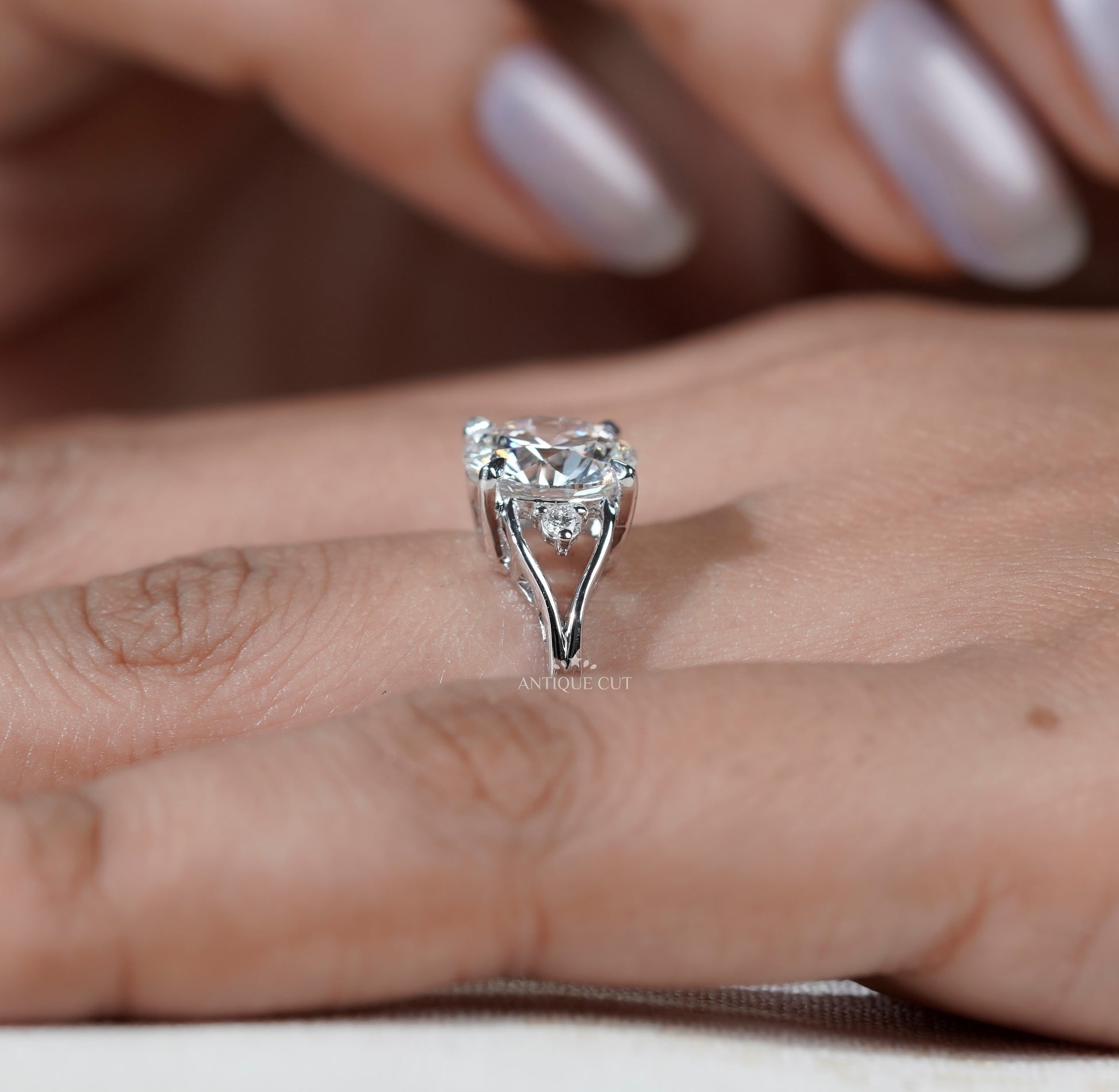 Round cut solitaire ring with decorative white gold shoulders