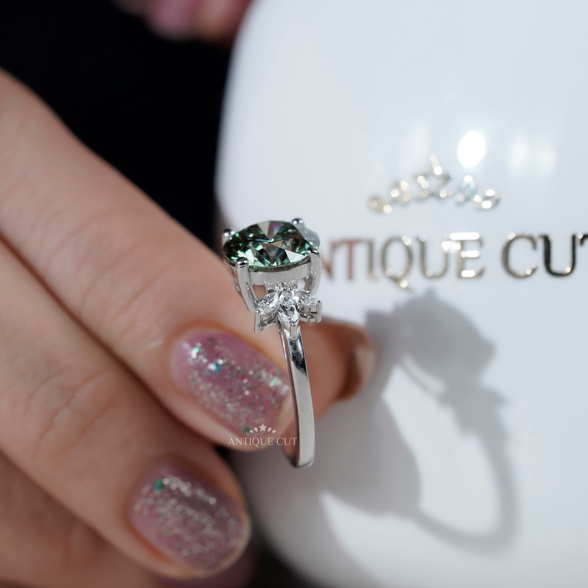 Elegant round cut green diamond ring with side stones