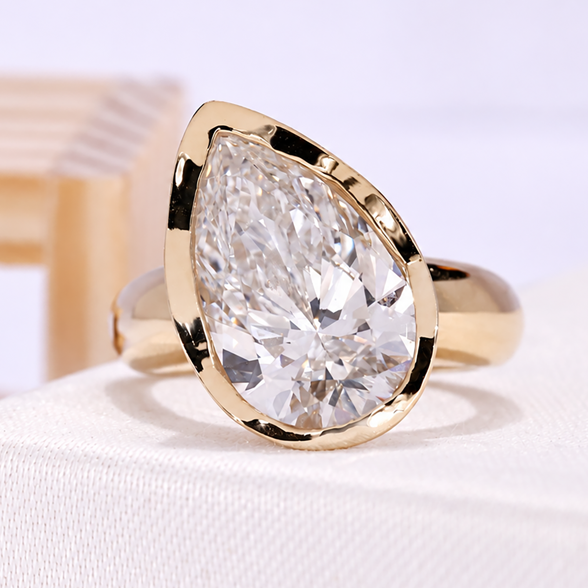 5.00 carat pear lab grown diamond ring with bezel setting in yellow gold