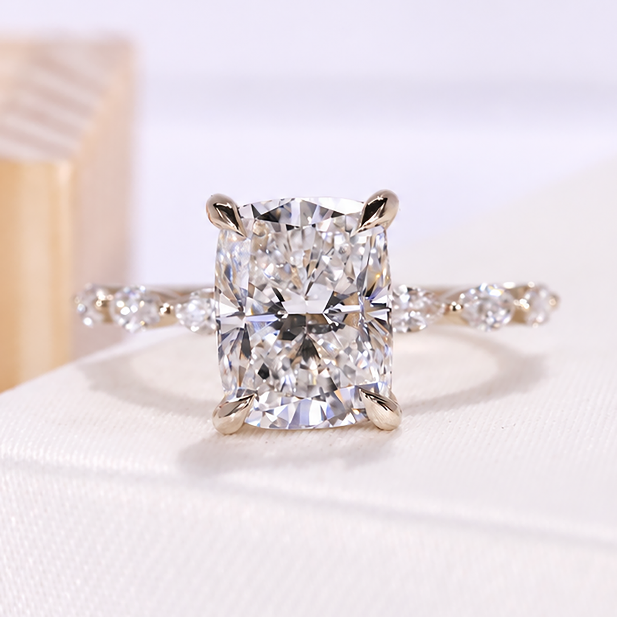  cushion lab grown diamond engagement ring with hidden halo and side stones in yellow gold