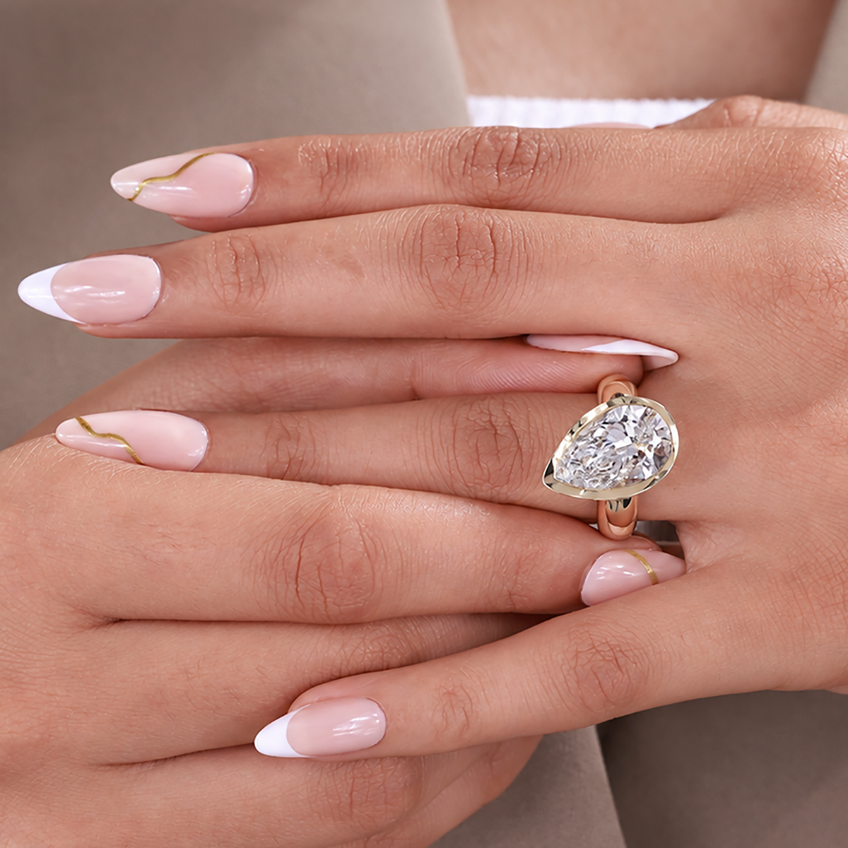 Yellow gold pear engagement ring with lab grown diamond and smooth bezel frame