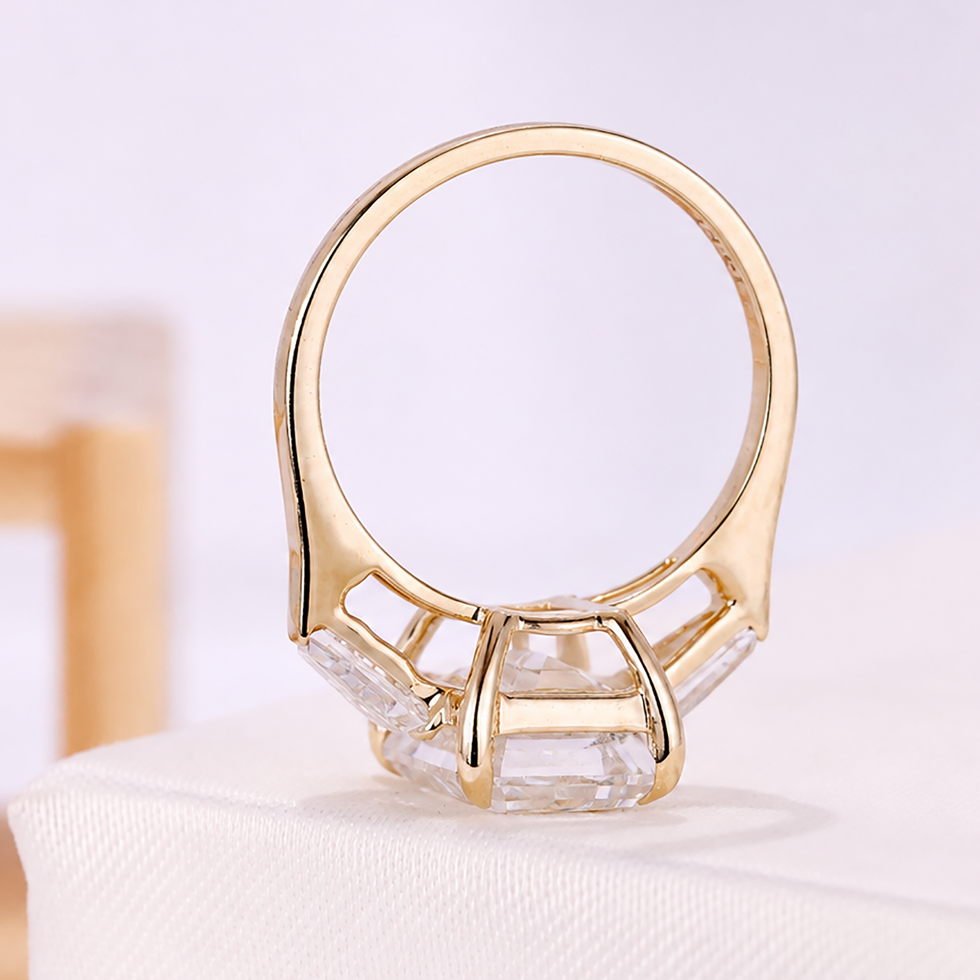 Yellow gold engagement ring with emerald cut center diamond