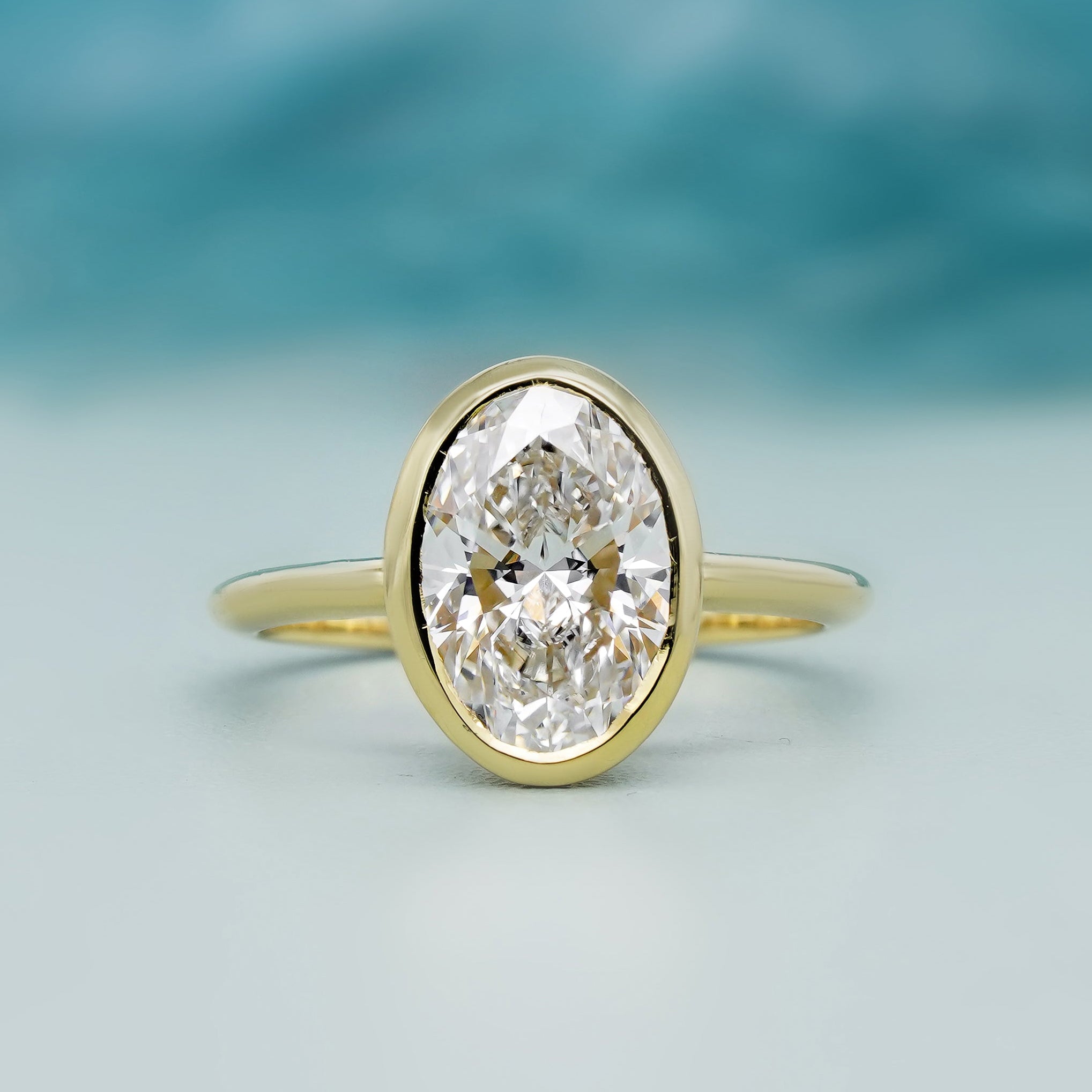 Bezel set oval engagement ring in yellow gold