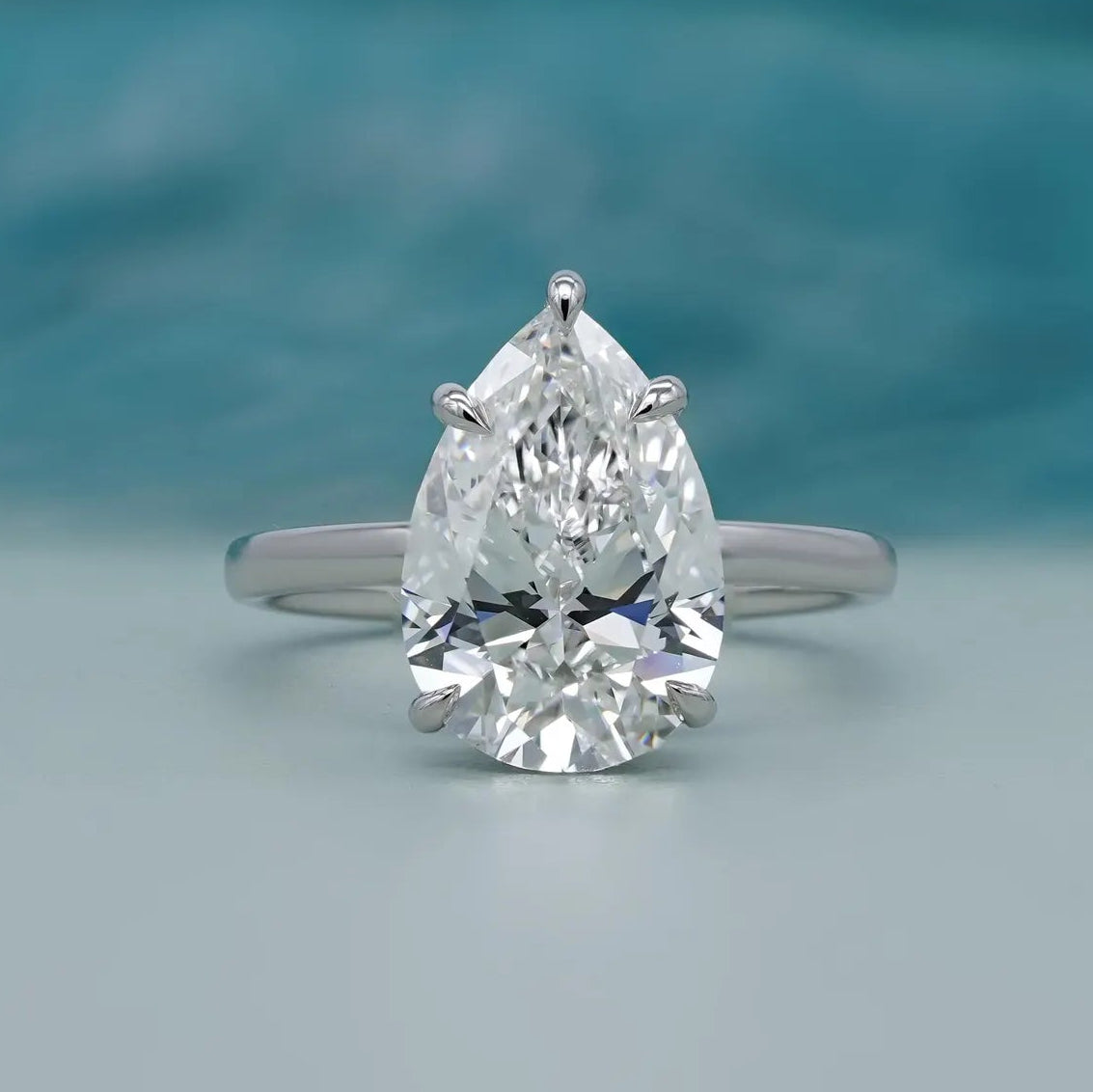 Hidden halo pear engagement ring in white gold