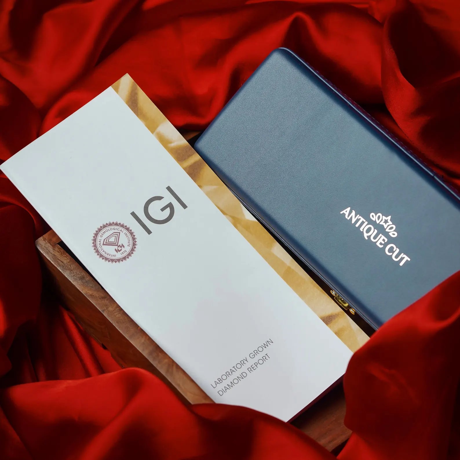 IGI diamond report card and a blue jewelry box on red fabric

