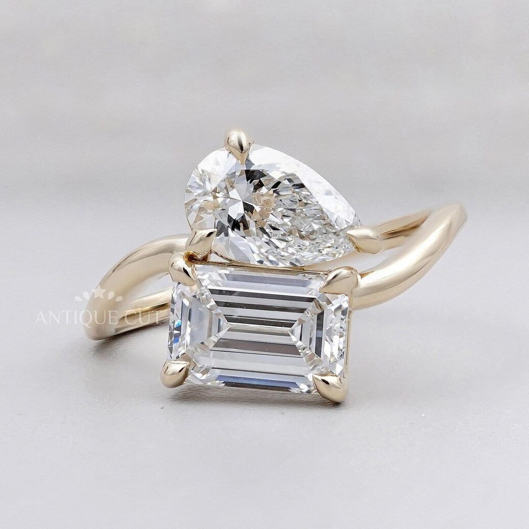 Emerald cut engagement ring with pear side stones yellow gold