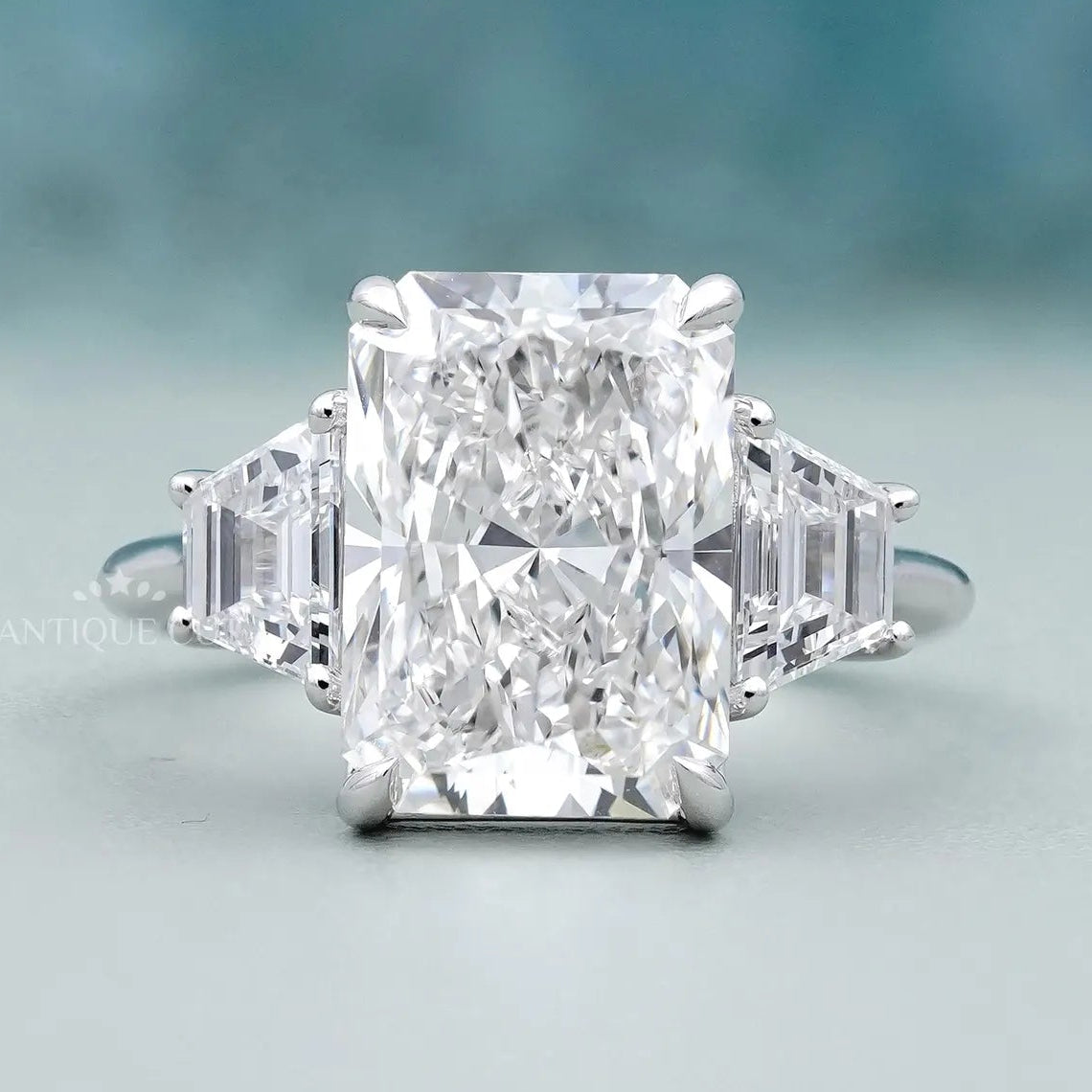 Radiant cut diamond engagement ring with trapezoid side stones in white gold