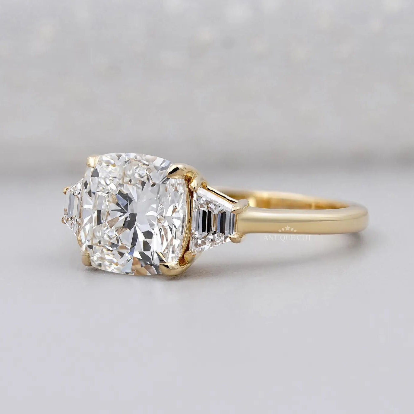 Three stone diamond engagement ring with cushion center diamond