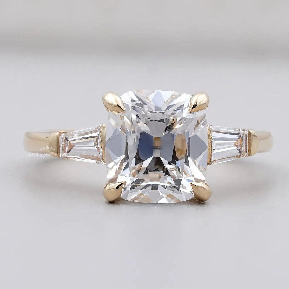 Old mine cushion cut engagement ring in yellow gold three stone