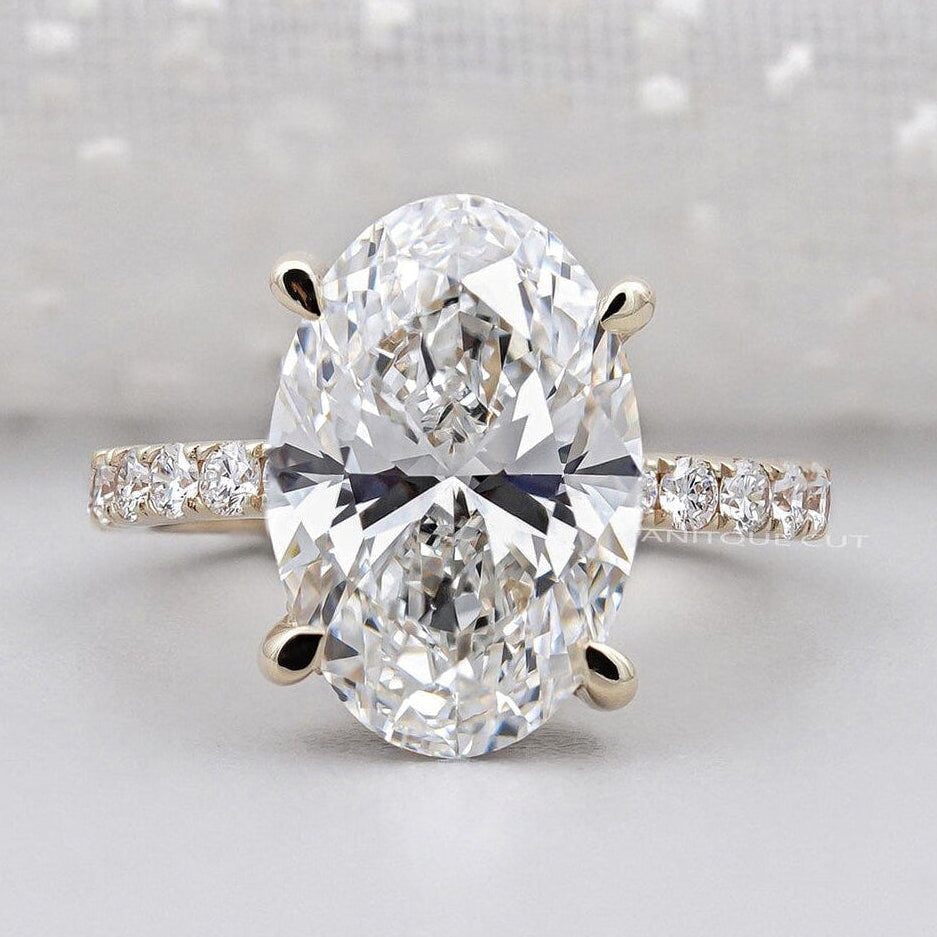 Oval cut hidden halo engagement ring with round diamond pave band