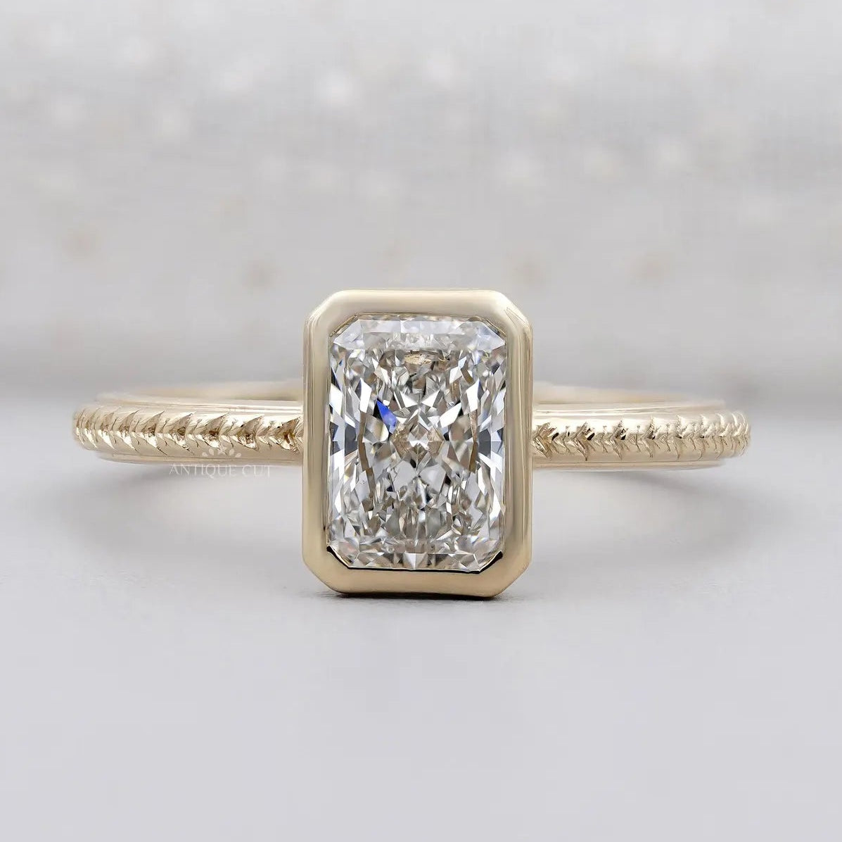 Radiant cut bezel set engagement ring in yellow gold