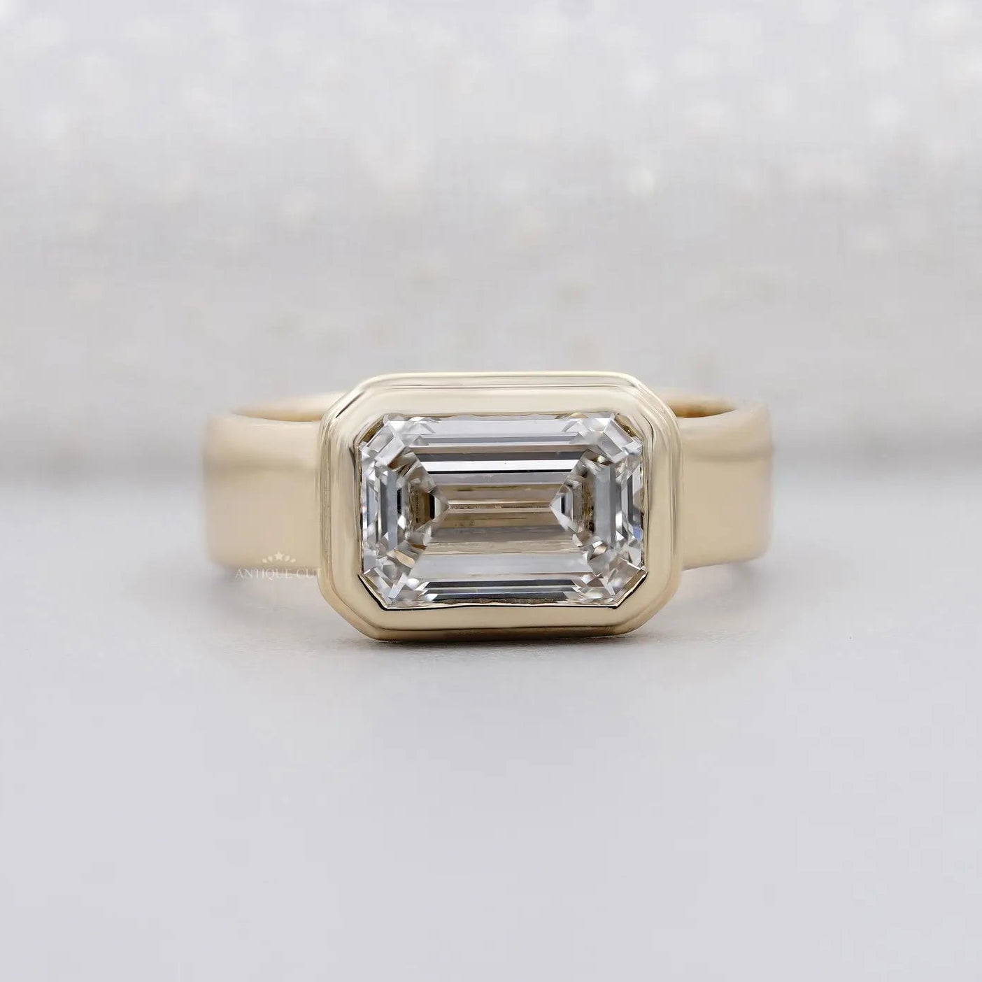 East West emerald cut engagement ring in yellow gold