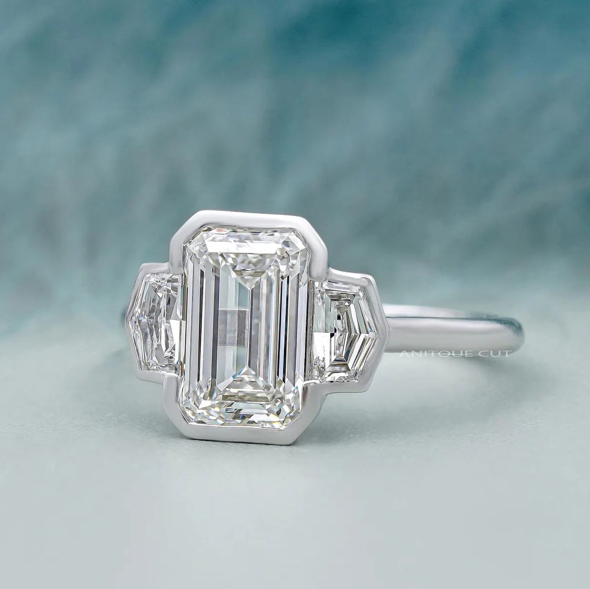 Lab grown emerald cut three stone engagement ring