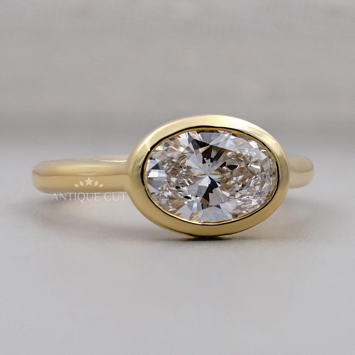 Oval diamond bezel engagement ring with hidden halo