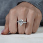 Hand wearing a diamond ring on a neutral background

