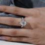 Close-up of a hand wearing a diamond ring with a blurred background

