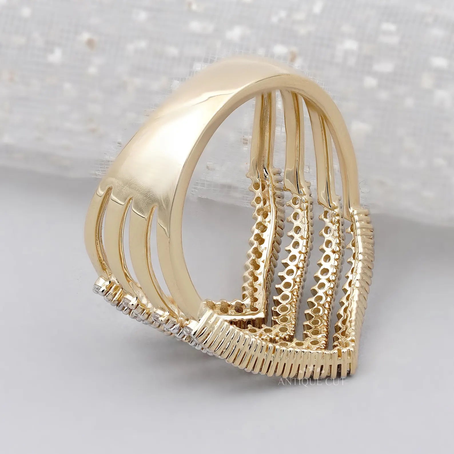 Gold and diamond ring on a light gray background

