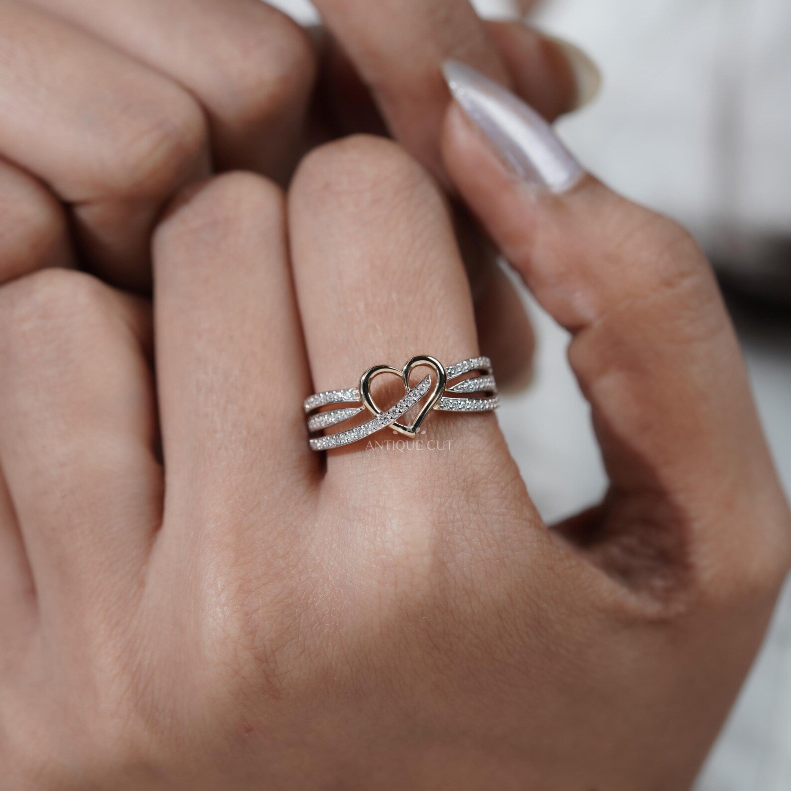 Silver ring with a heart design on hand