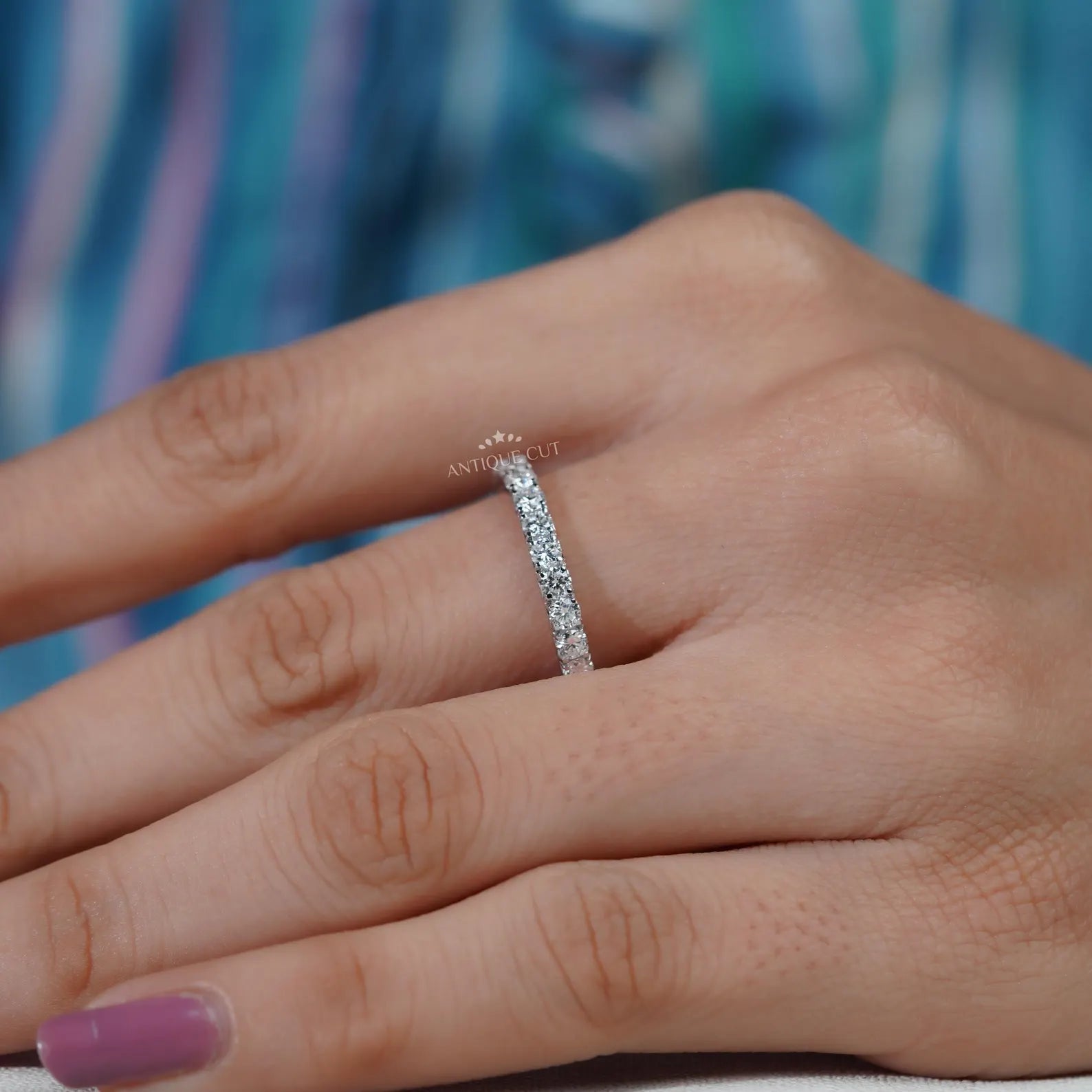 Silver ring with diamonds on a soft blue background

